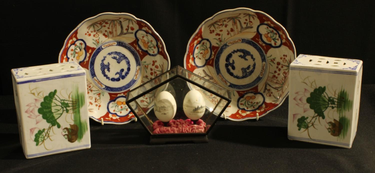 A pair of Japanese Imari porcelain dishes, Meiji period; a pair of Chinese pillow headrests; a