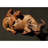 An early 20th century Chinese carving, two boys on a buffalo, approximately 21cm long