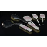 A silver and engine turned rose pink enamel five piece hand mirror and brush set, London 1959; a