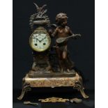 A late 19th century French spelter and marble mantel clock, mounted with a cherub musician, circular