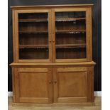 A farmhouse pine housekeeper's dresser or bookcase cabinet, of country house proportions, outswept