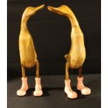 A pair of carved wooden ducks, each wearing pink lace-up boots, 61cm high