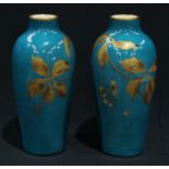 A pair of French faience slender ovoid shoulder vases, hand painted with leaves and berries in