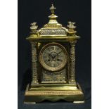 A Victorian brass mantel clock, Roman numerals to dial with twin winding holes, the dial inscribed