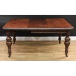 A late Victorian oak extending dining table, rounded rectangular top with carved edge, boldly turned