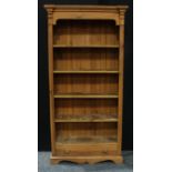 A farmhouse pine open bookcase, outswept cornice above four shelves and a long drawer, 200cm high,