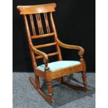 A late 19th century mahogany rocking chair, curved cresting rail, rectangular splats, scroll hand