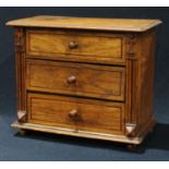 An early 20th century oak miniature chest of drawers, oversailing rounded rectangular top above