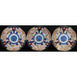 A set of three Japanese Imari shaped circular plates, painted in the typical palette with phoenixes,
