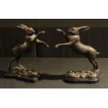 A pair of bronzed metal boxing hares, 29cm high