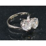 An 18ct white gold and cubic zirconia cross over ring, marked 750, Sheffield 1981, size Q, 6g