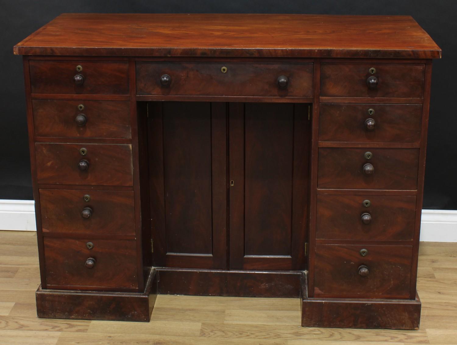 A Victorian mahogany kneehole desk, oversailing rectangular top above three frieze drawers, a pair