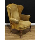 A George II style wingback armchair, scroll arms, stuffed over upholstery, cabriole forelegs, pad