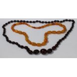 A strand of graduated cherry amber beads; a strand of graduated butterscotch amber coloured beads (
