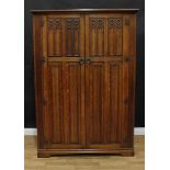 A Gothic design oak hall robe/wardrobe, outswept cornice above a pair of panel doors, carved and