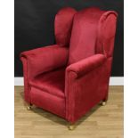 A George III style wingback armchair, scroll arms, stuffed over upholstery, 109cm high, 81cm wide,