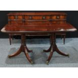 A Regency style twin-pillar dining table, rounded rectangular top with reeded edge, canon-barrel