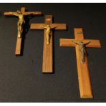 A gilt metal corpus Christi, hardwood cross, 30cm long; another, brass inlaid; another (3)