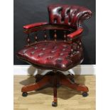 A Victorian style swivel desk or 'captain's' chair, stuffed-over deep button oxblood upholstery,