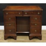 A George III style mahogany kneehole desk, rectangular top with inset tooled and gilt writing