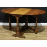 A 17th century style oak gateleg dining table, oval top with fall leaves, turned supports, trestle