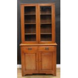 An Arts & Crafts design oak bookcase cabinet, shallow half gallery above a pair of glazed doors