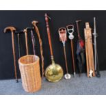 A wicker stick stand, walking sticks, shooting sticks, parasol, copper warming pan; etc