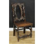 A Spanish Baroque design side chair, the back carved throughout with scrolls and flowerheads, the