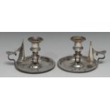 A pair of George IV silver chambersticks, campana sconces, dished circular bases, scroll handles