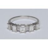 A contemporary design graduated step cut diamond ring, five graduated raised tower claws each