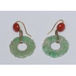 A pair of carved green stone and coral drop earrings, each with a carved floral green stone ring