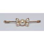 A cultured pearl mounted bar brooch, centrally set with five mixed sized globular creamy white