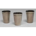 A set of three Russian silver tapered cylindrical vodka cups, textured finish, gilt interiors, 5.5cm