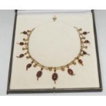 A Late Victorian foil back garnet festoon necklace, with eleven graduated oval cabochon foil