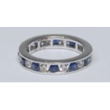 A diamond and sapphire eternity ring, open channel alternate set with twelve round brilliant cut