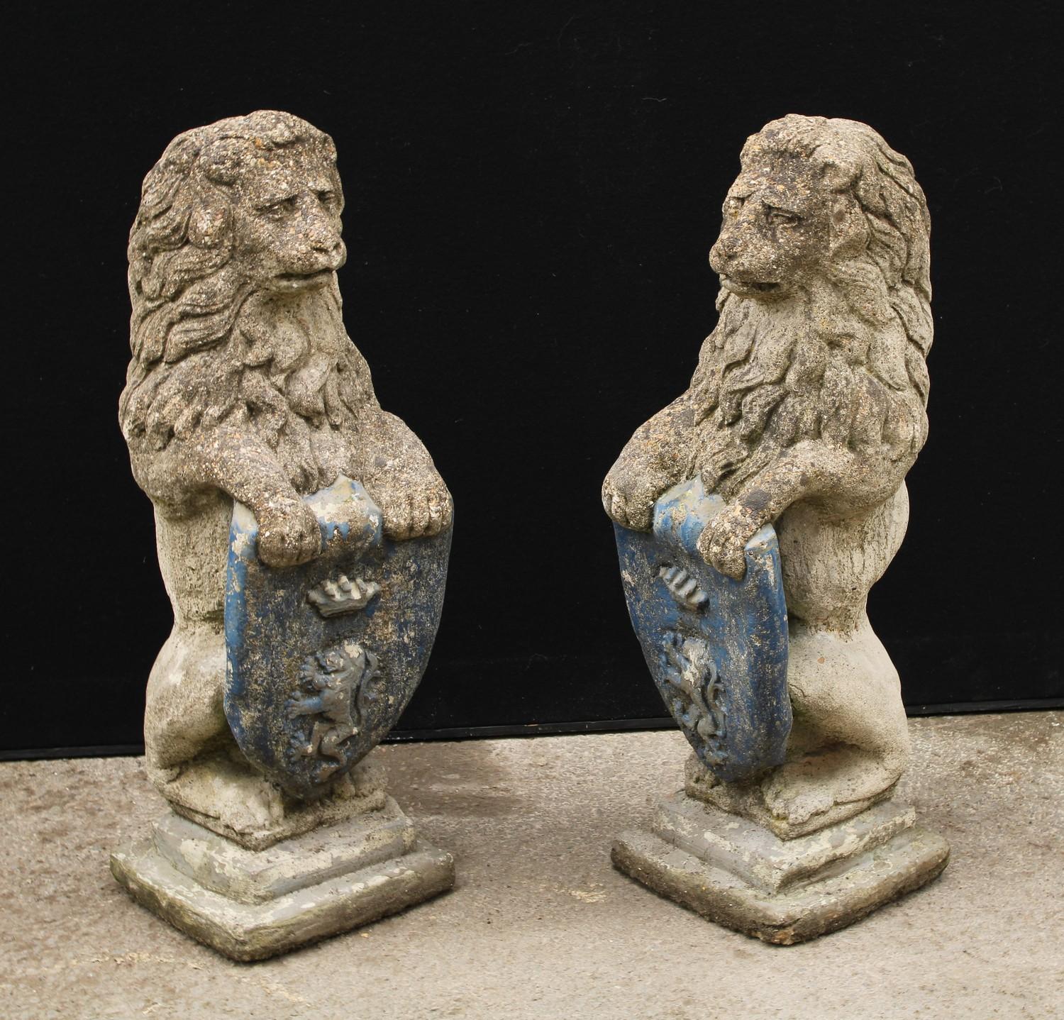 A pair of reconstituted stone heraldic lions, each grasping a shield, stepped bases, 74cm high, 26cm - Bild 2 aus 3