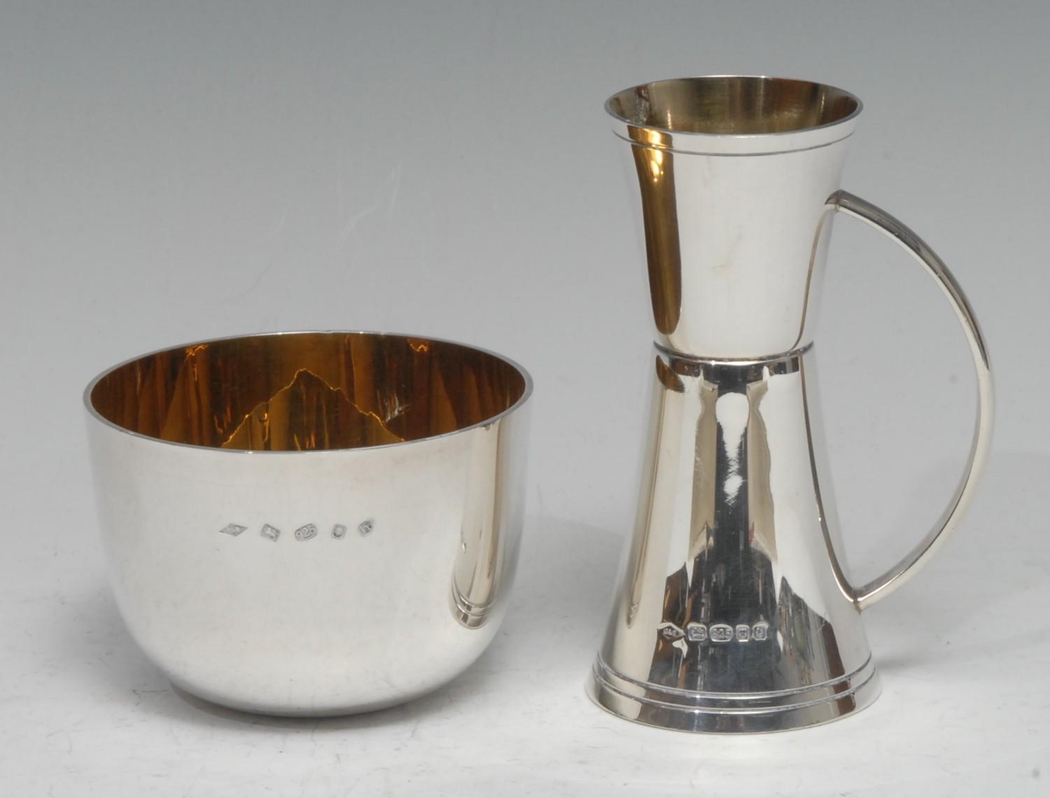 A silver tumbler, gilt lined, London 2007; a silver spirit measure with handle, gilt lined, London