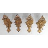 A set of four Rococo Revival gilt metal curtain pole brackets, each cast with a amorini mask