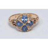 A sapphire and diamond cluster ring, inset with four pale blue pear cut sapphires and four old round