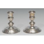 A pair of Elizabeth II silver candlesticks, in the George I taste, 11cm high, William Comyns &