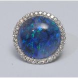 A large black opal and diamond cluster ring, central circular black opal cabochon, measuring