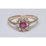 A diamond and ruby cluster ring, central round cut ruby surrounded by a collar of eight brilliant