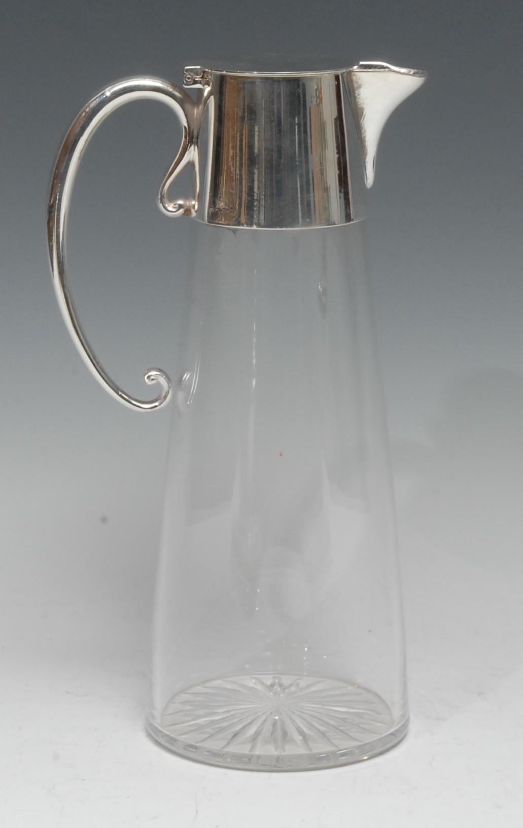 An Edwardian E.P.N.S mounted clear glass spreading cylindrical claret jug, hinged cover, scroll