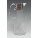 An Edwardian E.P.N.S mounted clear glass spreading cylindrical claret jug, hinged cover, scroll