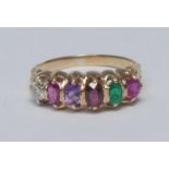 A multi gem regard ring, linear set with mixed cut oval gemstones, ruby, emerald, garnet,