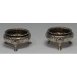 A pair of Victorian silver cauldron salts, of George II design, each chased with a band of flowers