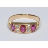 A ruby and diamond ring, inset with three oval cut red rubies, each divided by a pair of old