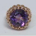 A retro amethyst dress ring, large vibrant purple amethyst within gold coloured wire work petal