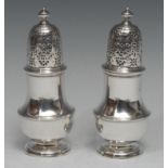 A pair of George I/II silver pear shaped casters, knop finials, pierced bell shaped covers, cast