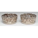 A pair of early Victorian silver circular wine coasters, each deep shaped gallery cased and chased